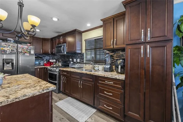 a kitchen with granite countertop wooden cabinets and stainless steel appliances