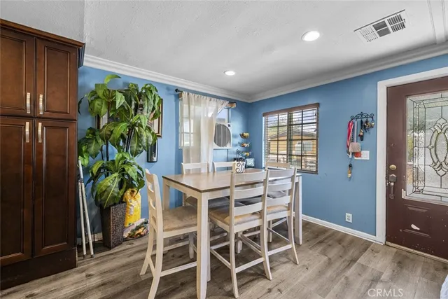 a dining room with furniture potted plants and wooden floor