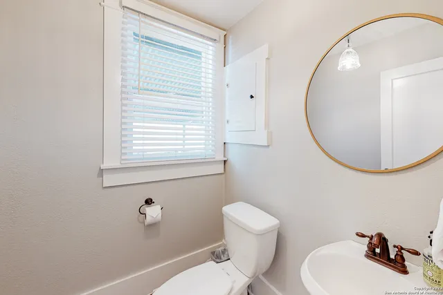 a bathroom with a sink a toilet and a mirror