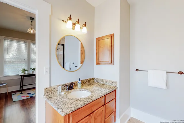 a bathroom with a granite countertop sink and a mirror