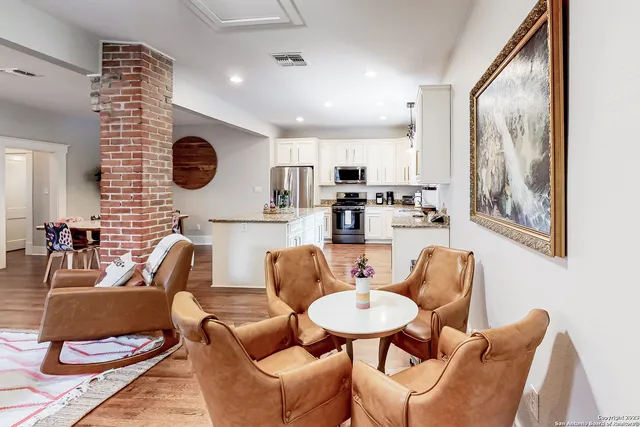 a living room with furniture kitchen and a large window