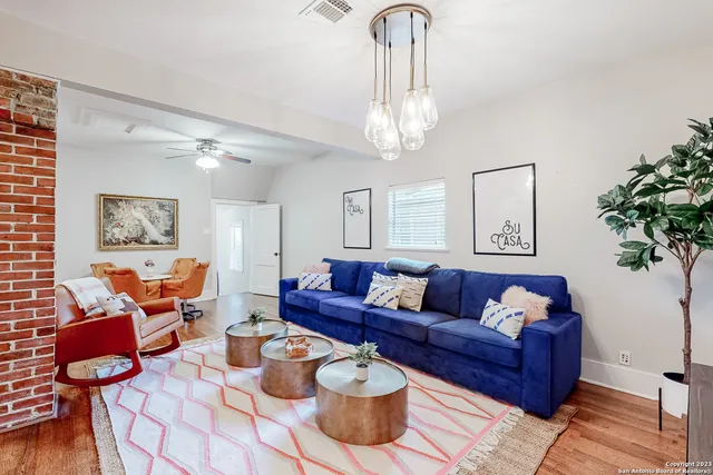 a living room with furniture a chandelier and a potted plant