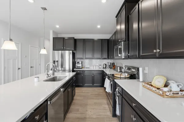 a living room with furniture wooden floor and kitchen view