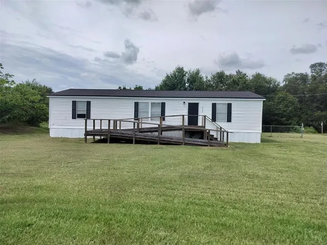 a view of a house with backyard and a garden