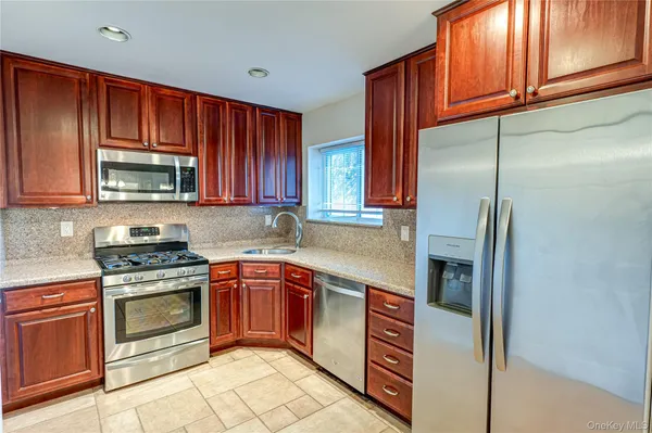 a kitchen with stainless steel appliances granite countertop a stove top oven a sink and dishwasher