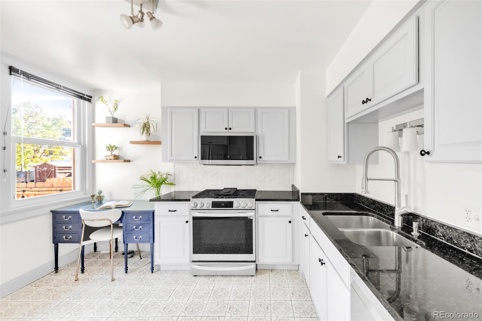 3244 Clay Street Denver, CO 80211 - Photo 12 of 28 a kitchen with granite countertop a sink stainless steel appliances and white cabinets