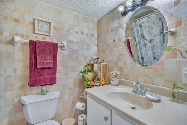 a bedroom with a bed and dresser with wooden floor