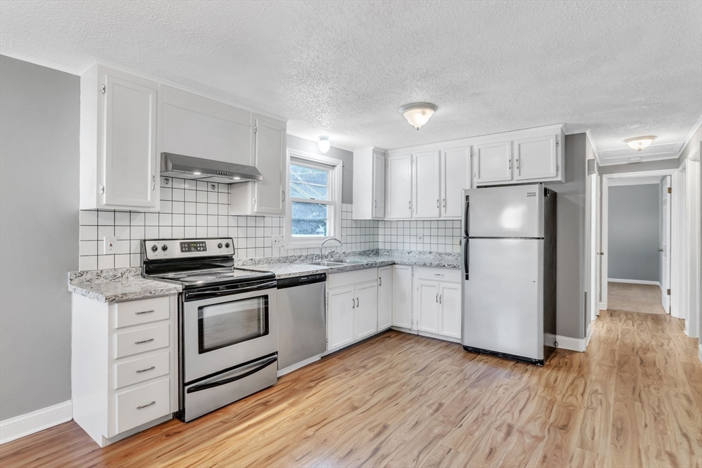 65 Puritan Road Springfield, MA 01119 - Photo 8 of 25 a kitchen with granite countertop a refrigerator stove top oven and sink