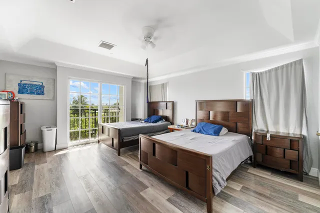 a bedroom with a bed a large window and furniture