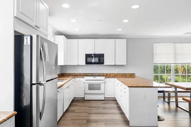 a kitchen with stainless steel appliances granite countertop a refrigerator a stove a sink and a microwave