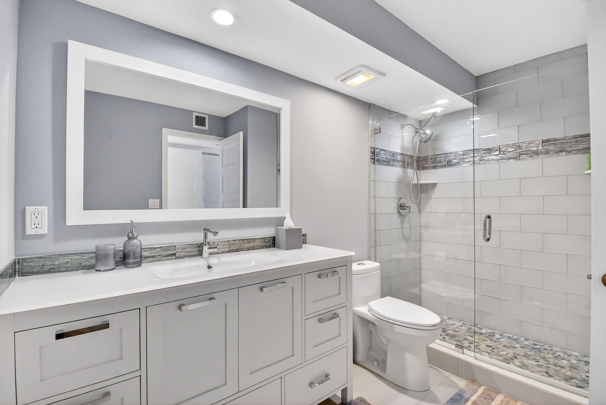 5540 North Ocean Drive, Unit 9B Singer Island, FL 33404 - Photo 11 of 57 a bathroom with a toilet a sink a glass door a shower a mirror and vanity