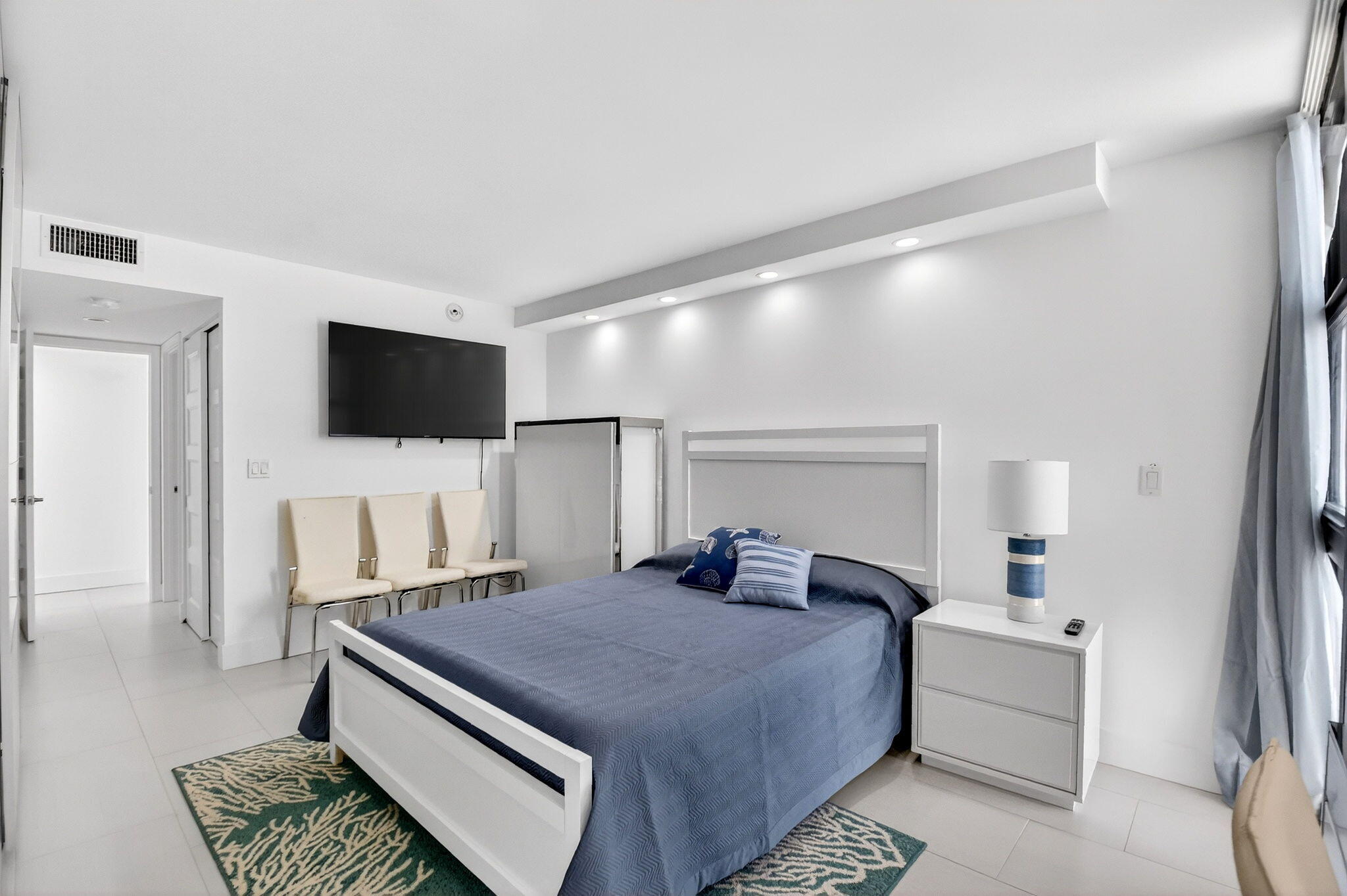 5540 North Ocean Drive, Unit 9B Singer Island, FL 33404 - Photo 10 of 57 a bedroom with a bed and a flat screen tv