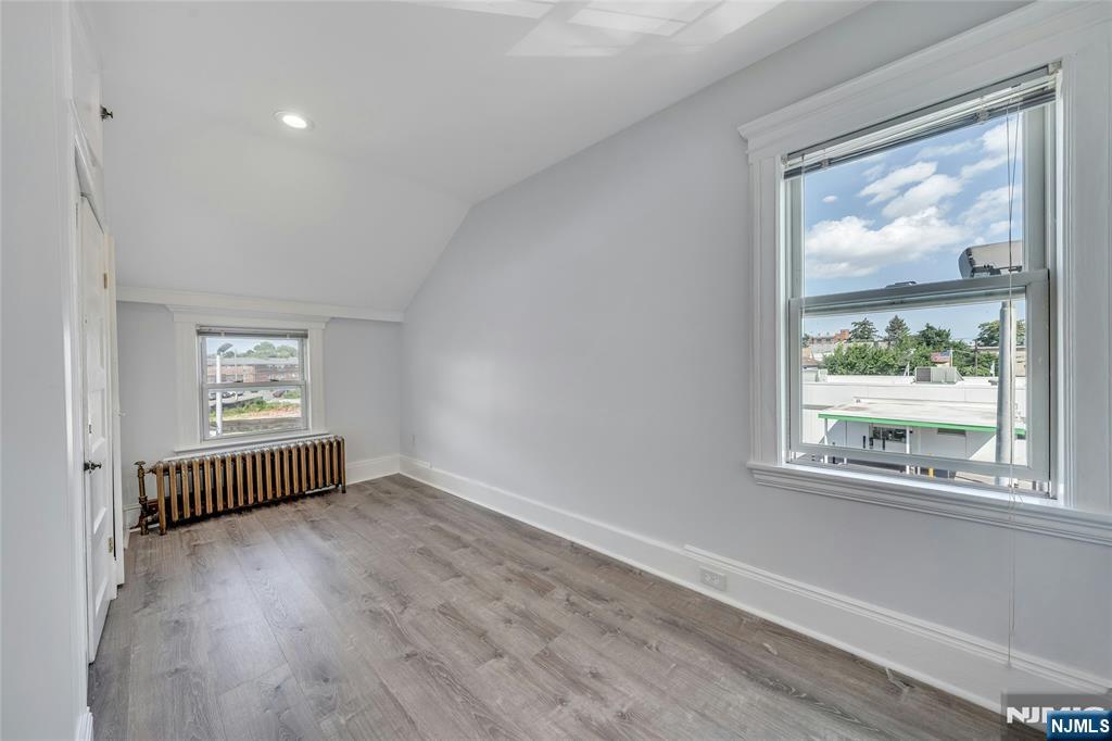 425 Hancock Place Fairview, NJ 07022 - Photo 15 of 31 an empty room with wooden floor and windows