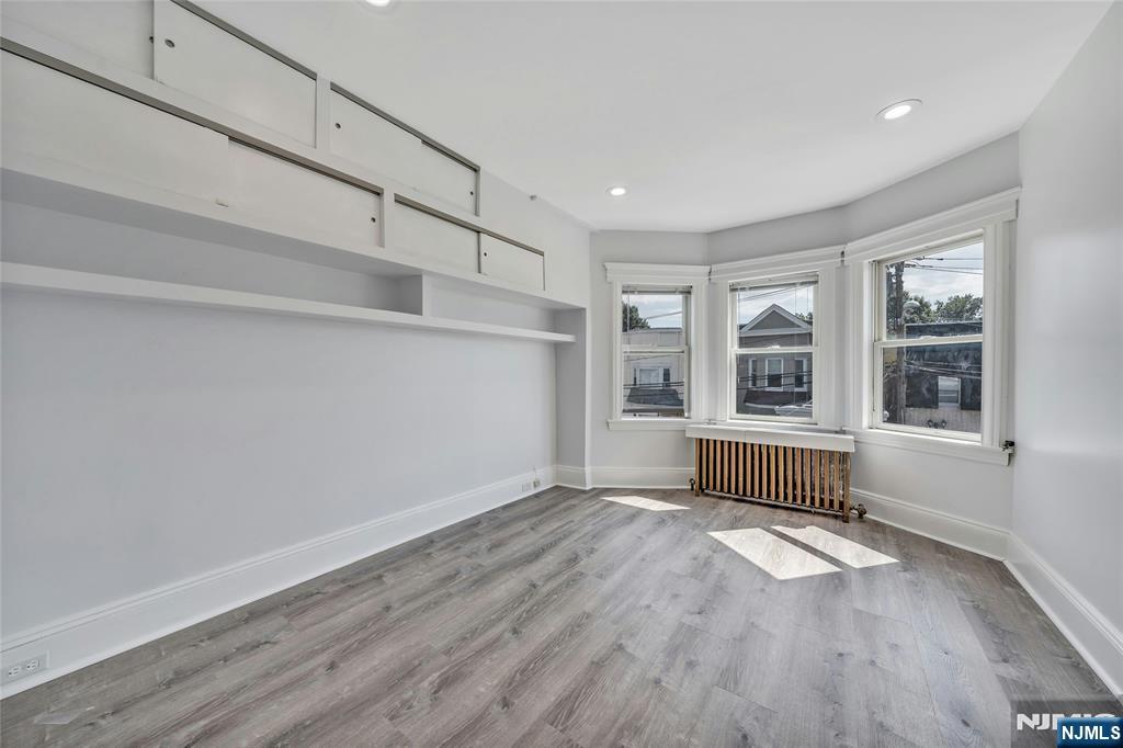 425 Hancock Place Fairview, NJ 07022 - Photo 17 of 31 a view of empty room with wooden floor and fan