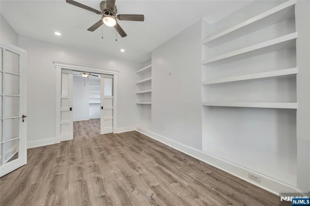 425 Hancock Place Fairview, NJ 07022 - Photo 22 of 31 wooden floor in an empty room with a ceiling fan