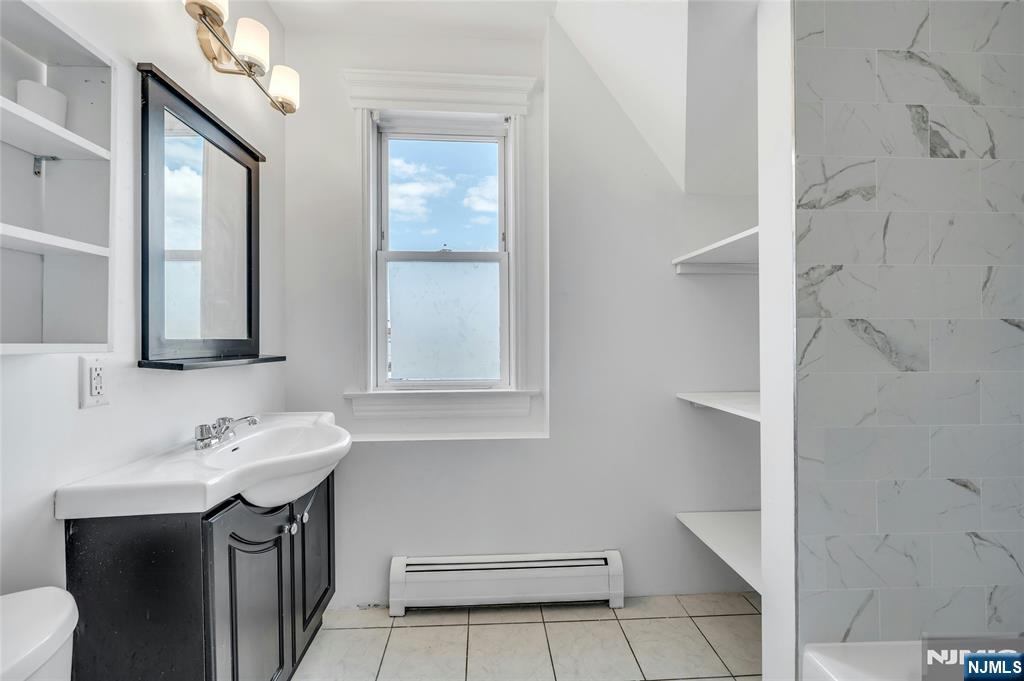 425 Hancock Place Fairview, NJ 07022 - Photo 24 of 31 a bathroom with a sink vanity and a mirror