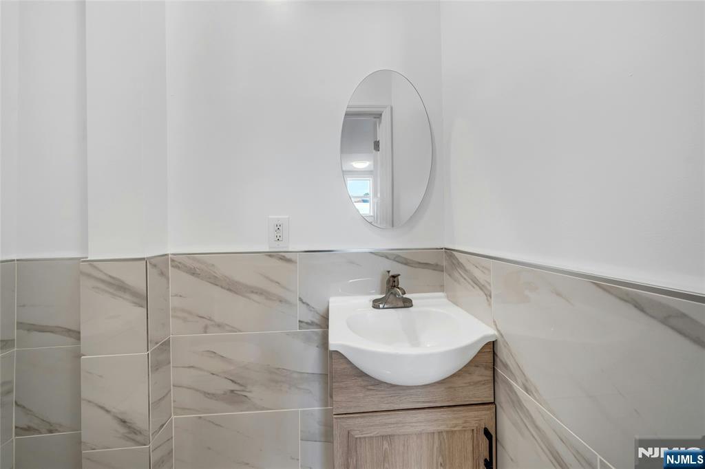425 Hancock Place Fairview, NJ 07022 - Photo 26 of 31 a bathroom with a sink and a mirror