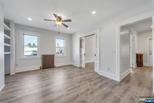 a view of empty room with wooden floor
