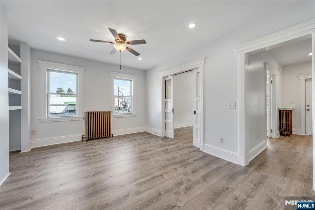 425 Hancock Place Fairview, NJ 07022 - Photo 7 of 31 wooden floor in an empty room with a window