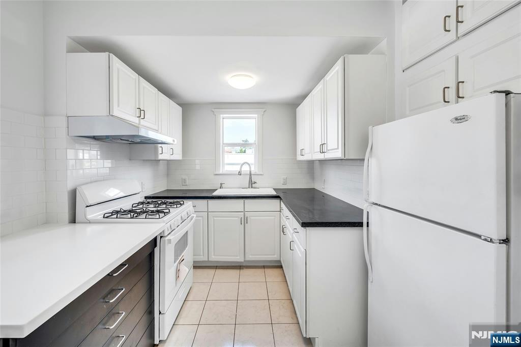 425 Hancock Place Fairview, NJ 07022 - Photo 9 of 31 a kitchen with a stove a refrigerator and a sink