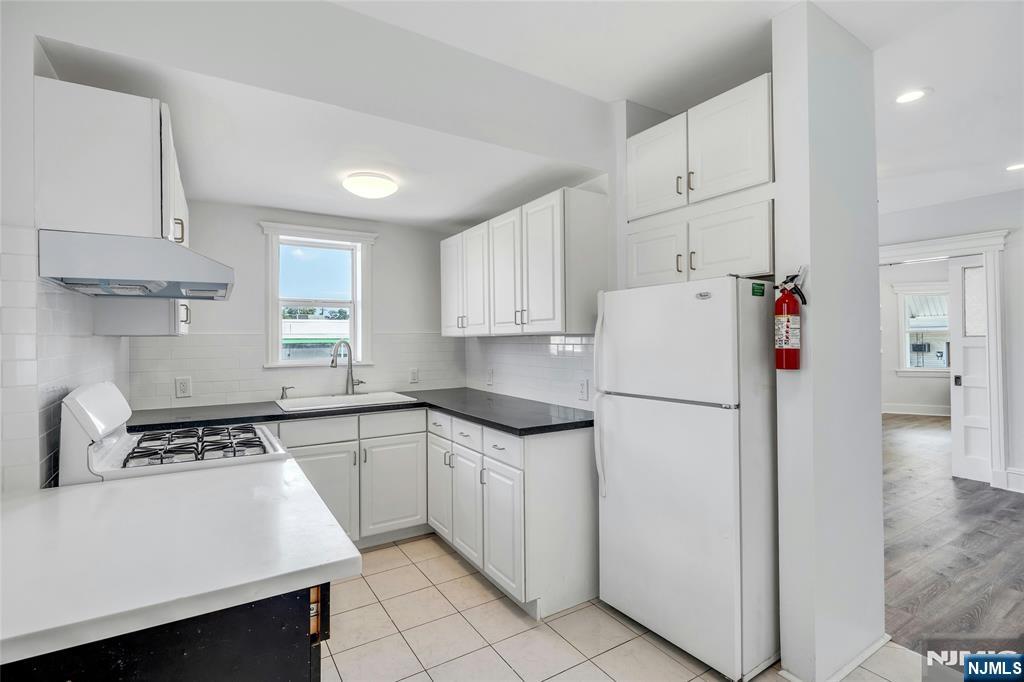 425 Hancock Place Fairview, NJ 07022 - Photo 10 of 31 a kitchen with white cabinets and white appliances
