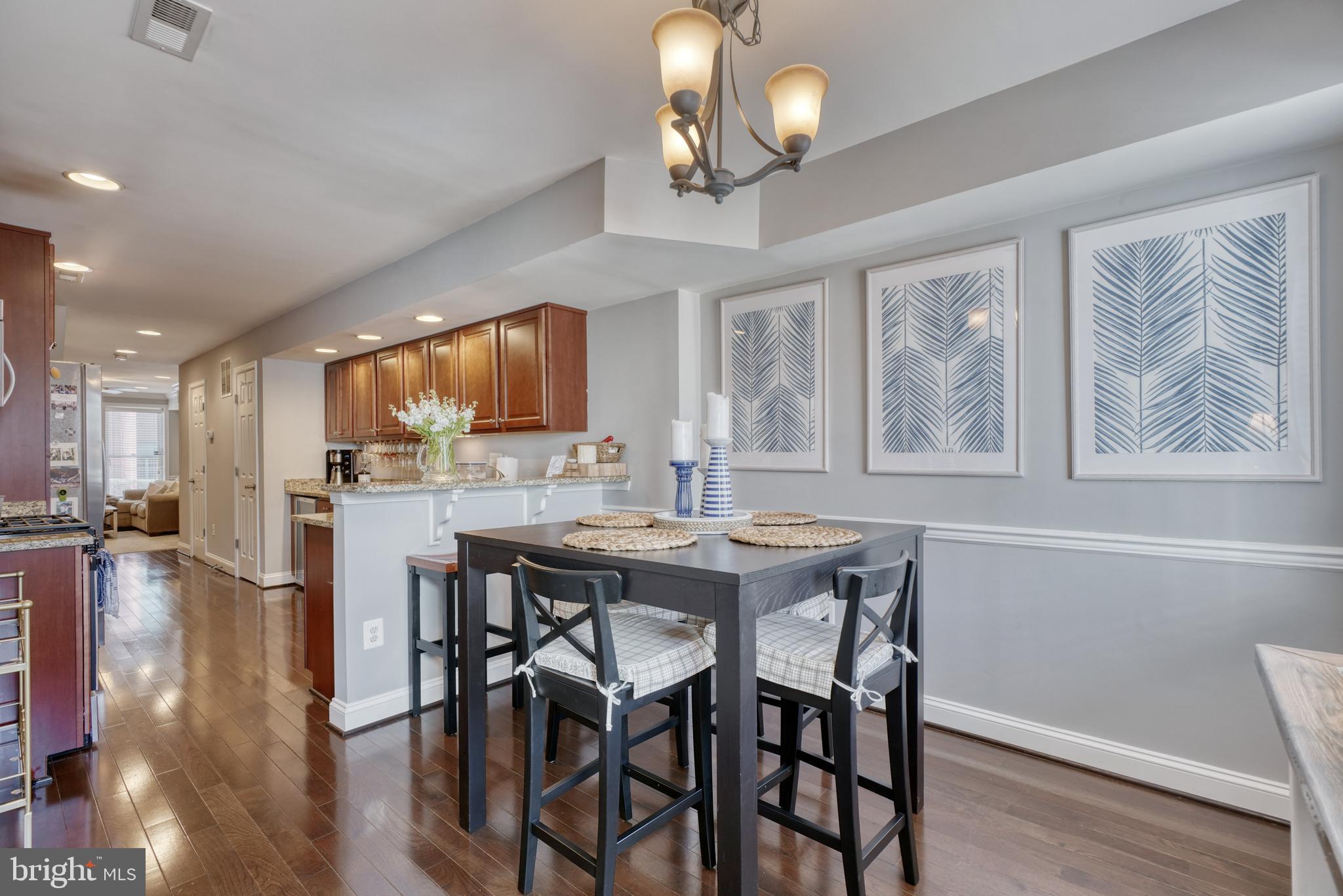 1818 Byrd Street Baltimore, MD 21230 - Photo 20 of 48 a dining room with wooden floor a chandelier a wooden table and chairs