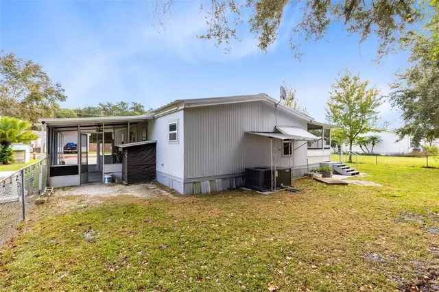 a view of a house with a yard patio and a tree