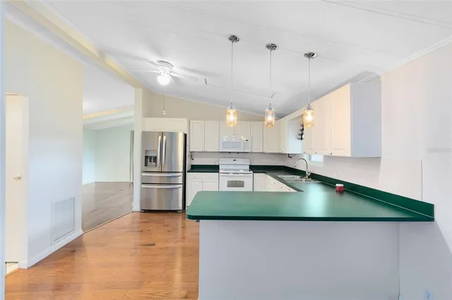 a kitchen with kitchen island a stove a refrigerator and a sink