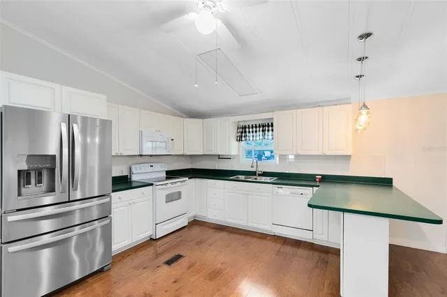 a kitchen with granite countertop a sink stove and refrigerator