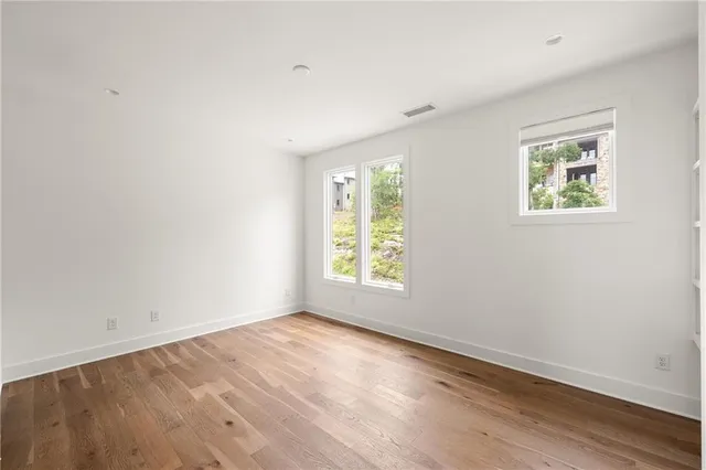 an empty room with wooden floor and window