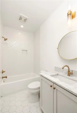 a bathroom with a granite countertop sink a toilet and a bathtub
