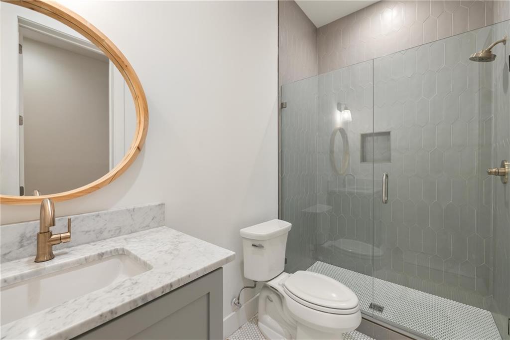 10904 Serenbe Lane Palmetto, GA 30268 - Photo 18 of 23 a bathroom with a granite countertop sink toilet and shower