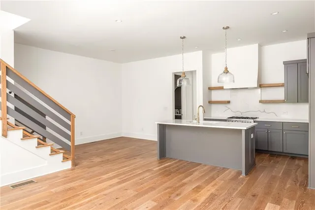 a kitchen with stainless steel appliances granite countertop a sink stove and refrigerator