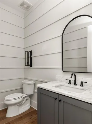 a bathroom with a toilet sink and mirror