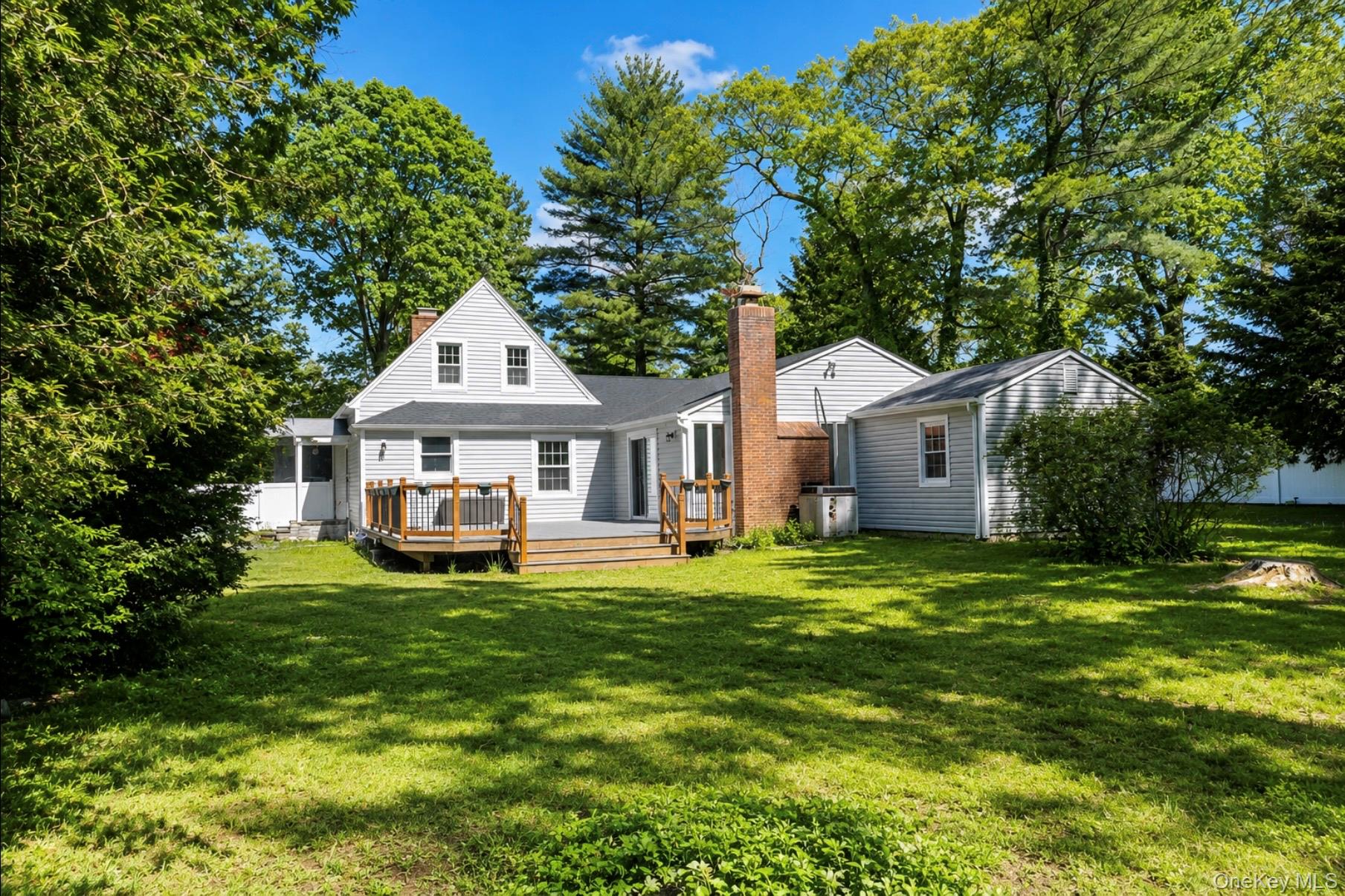 80 Mt Pleasant Road Smithtown, NY 11787 - Photo 22 of 27 a front view of a house with a garden and trees