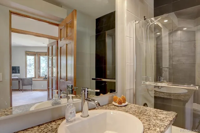 a bathroom with a granite countertop sink and a mirror