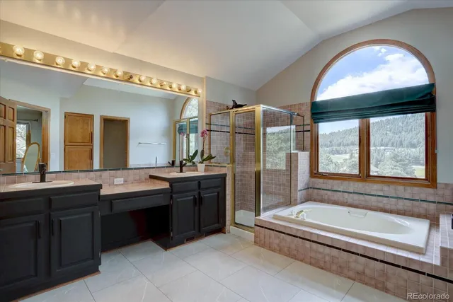 a spacious bathroom with a granite countertop tub and a large window