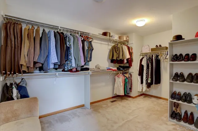 a view of walk in closet with clothes and shoes