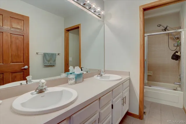 a bathroom with a double vanity sink mirror and bathtub