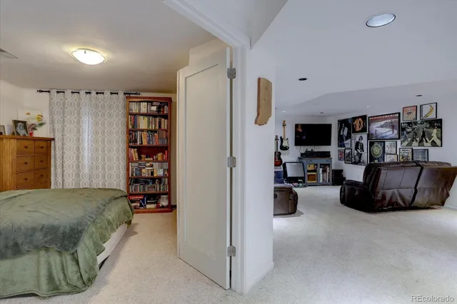 a bedroom with a bed a flat screen tv and dresser