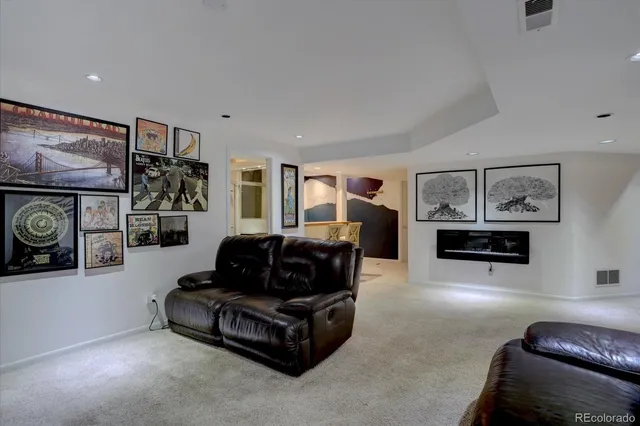 a living room with furniture a flat screen tv and a wall painting
