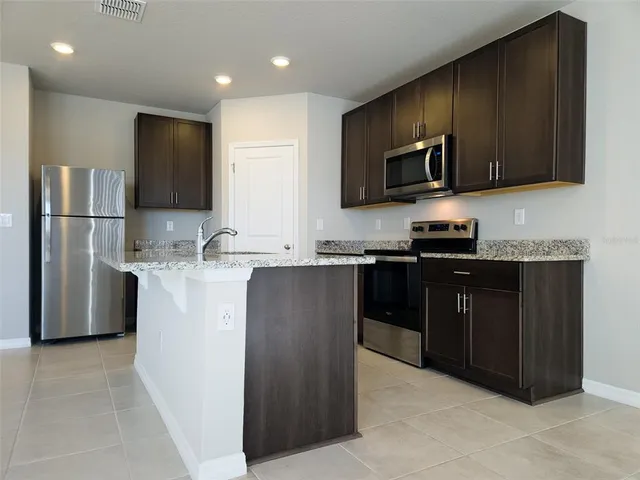 a kitchen with stainless steel appliances granite countertop a refrigerator stove a sink and dishwasher