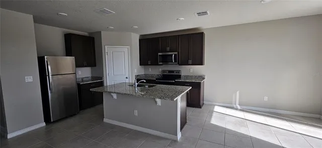 a kitchen with stainless steel appliances granite countertop a refrigerator and a sink