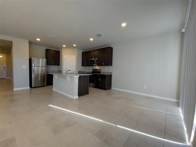 a view of kitchen with refrigerator and microwave