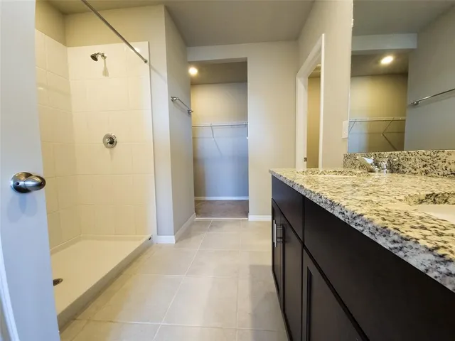 a bathroom with a granite countertop sink a shower and a mirror