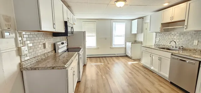 a kitchen with granite countertop a sink stove and cabinets