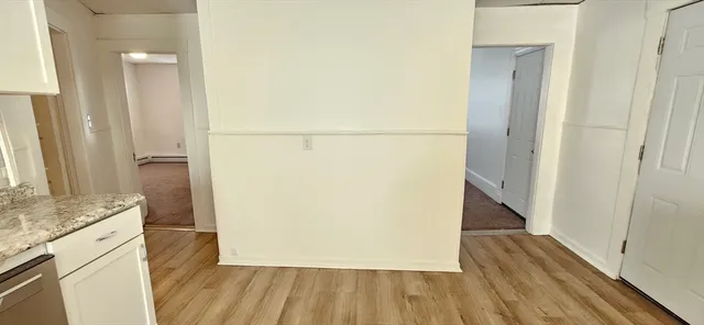 a view of a hallway with wooden floor and staircase