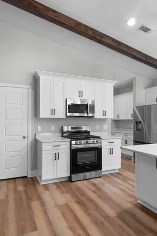 a kitchen with granite countertop a sink stainless steel appliances and cabinets