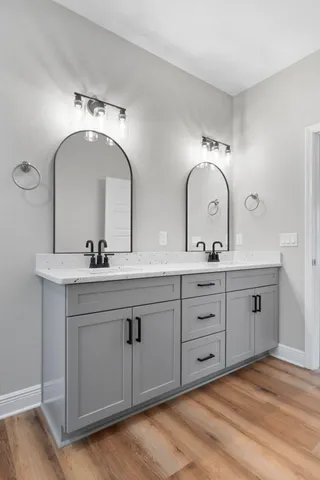 a bathroom with double vanity sinks and a mirror