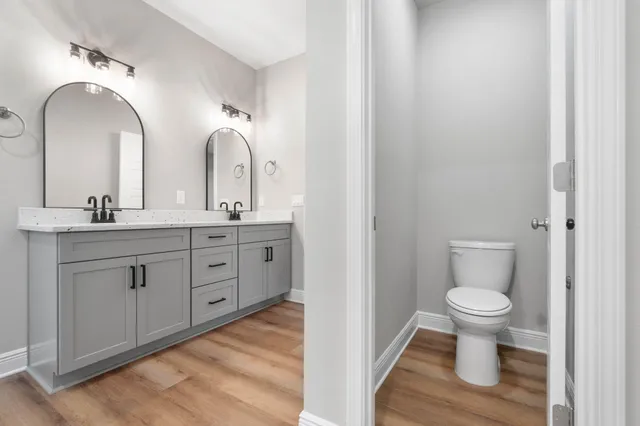 a bathroom with a double vanity sink and a toilet